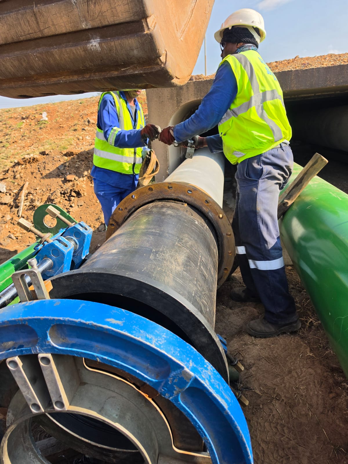 Wetpipe technicians jointing HDPE-lined pipeline through a concrete culvert on a mine site